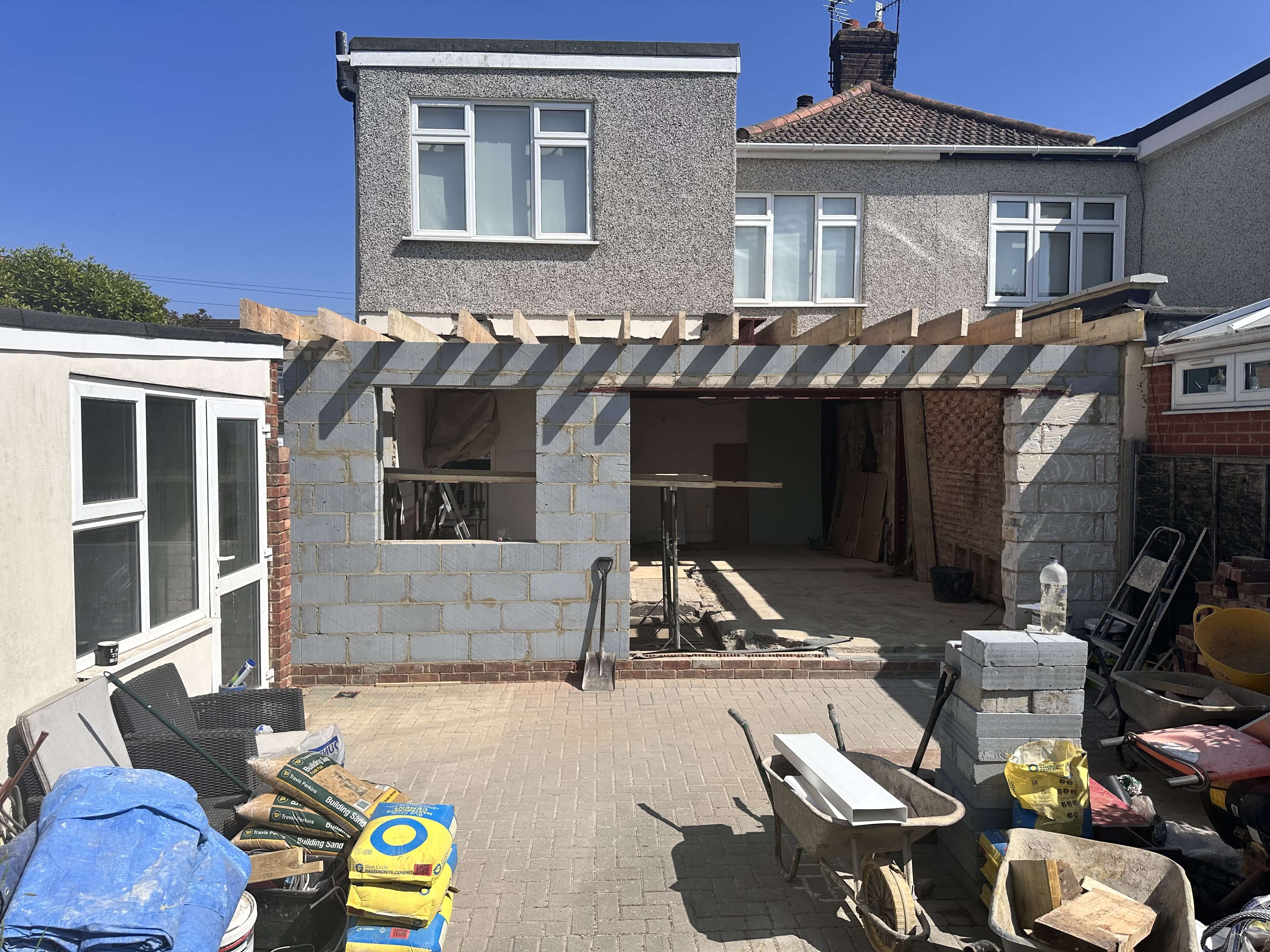 Single-storey rear extension under construction with new timber roof structure and blockwork walls