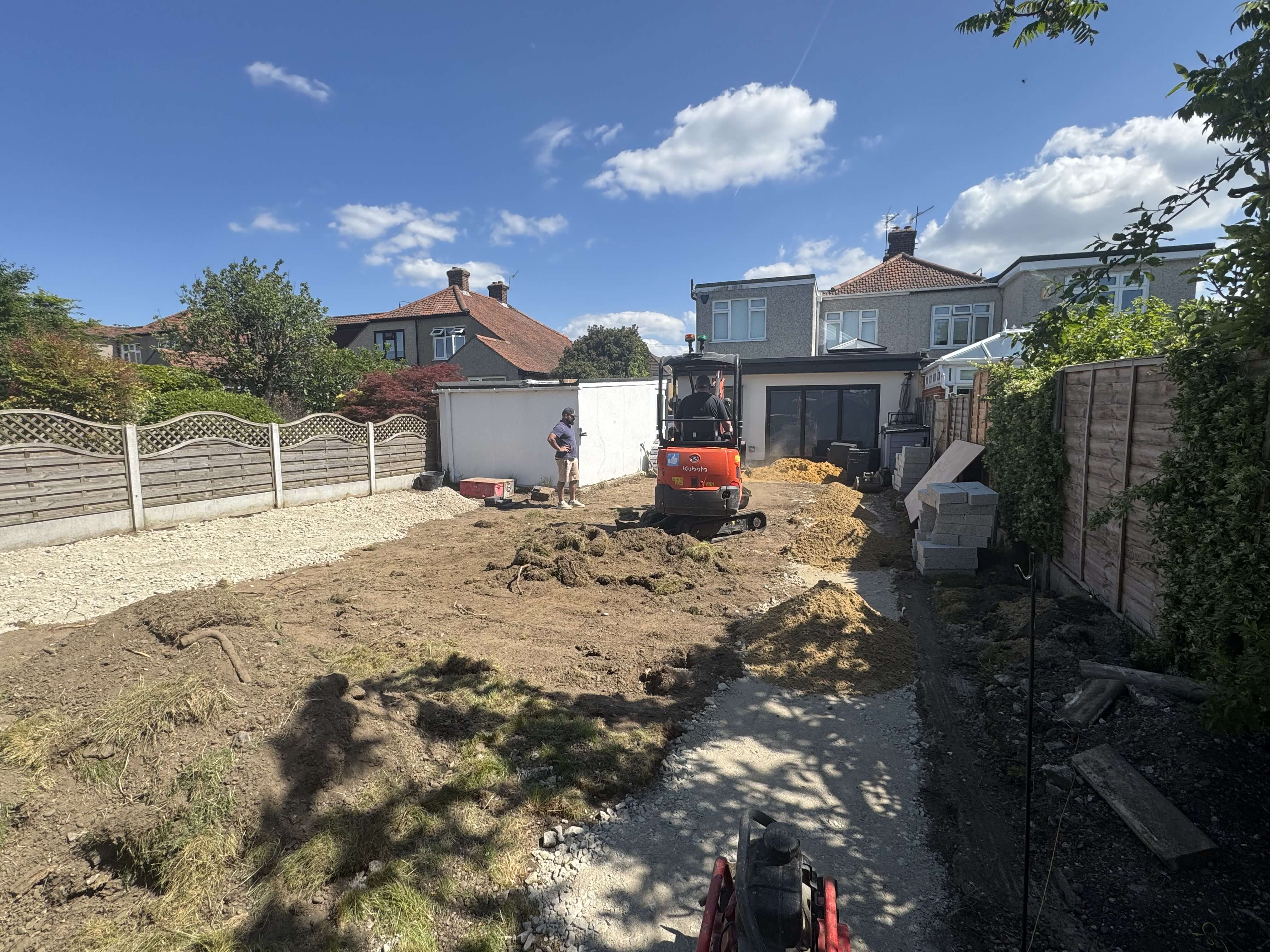 Wide rear garden with new groundworks underway and a 1930s semi-detached house in the background