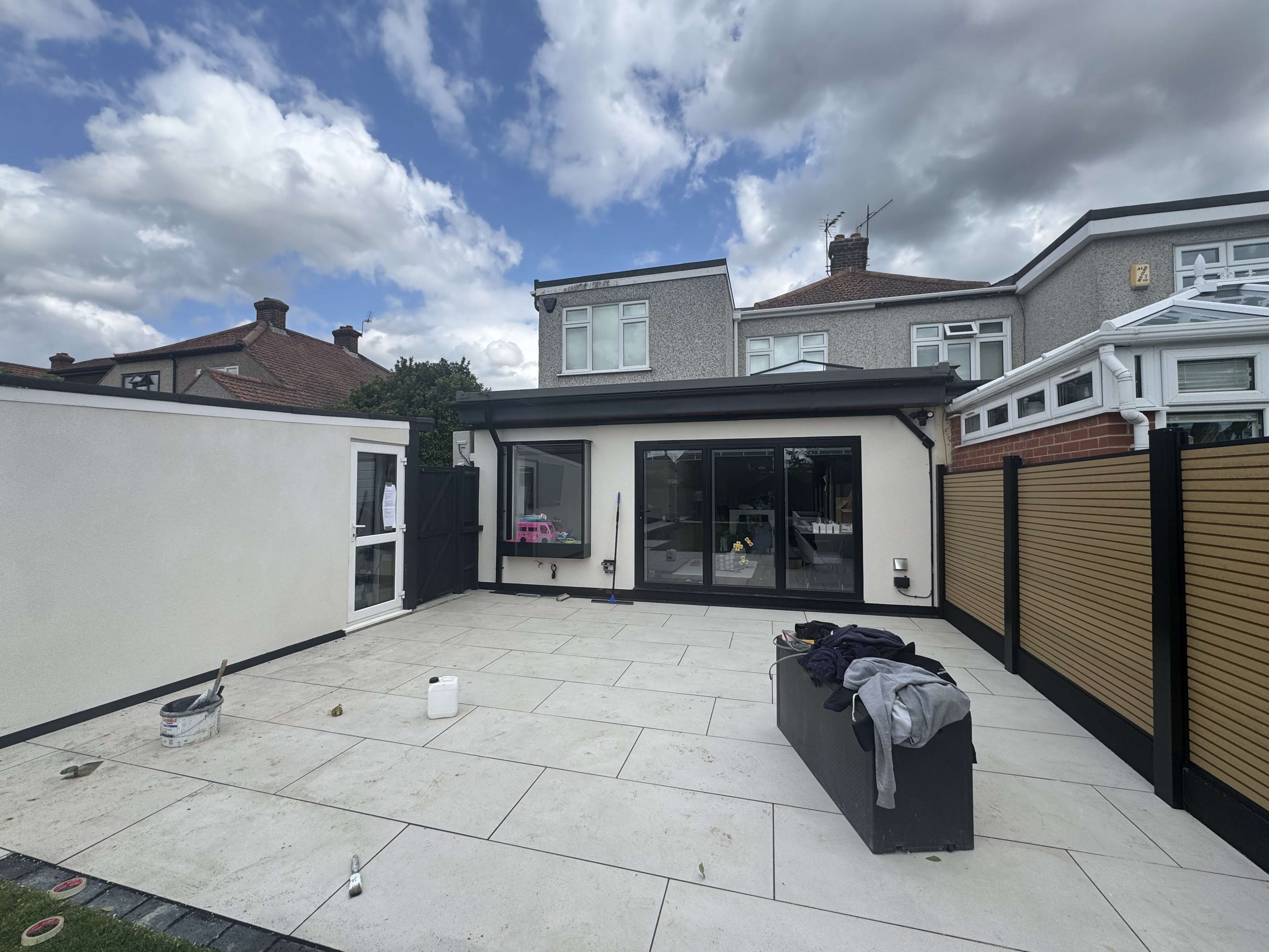 Modern rear extension with white render and full-width sliding doors opening onto a tiled patio