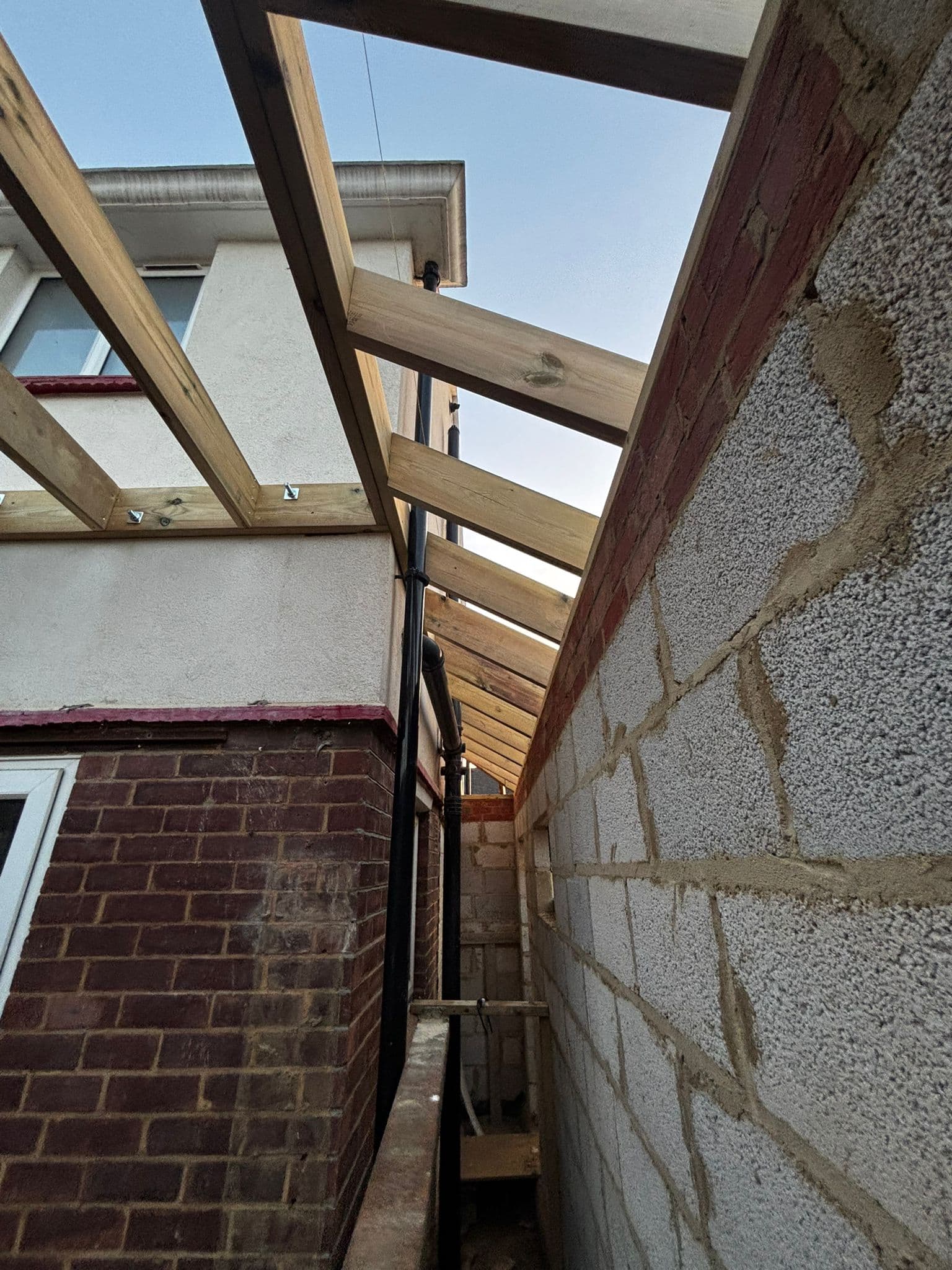 Side extension roof structure showing timber rafters bearing on steel beam and blockwork wall
